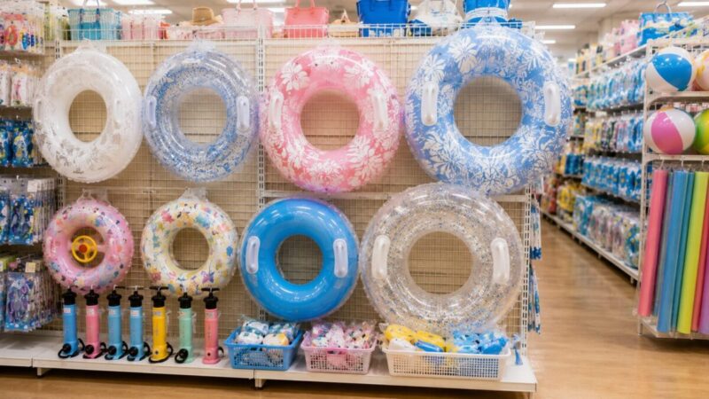 100均風の売り場で大人用と子供用の浮き輪サイズを比較するイメージ