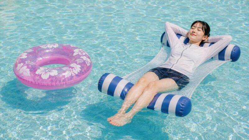 丸い浮き輪とフロートハンモックをプールで並べ、寝転びやすさと水に浸かる涼しさの違いを比較している様子