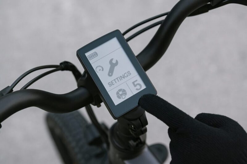 eBikeメーターの設定画面を操作する手元の写真。速度単位とホイール周長など初期設定を連想させる構図。