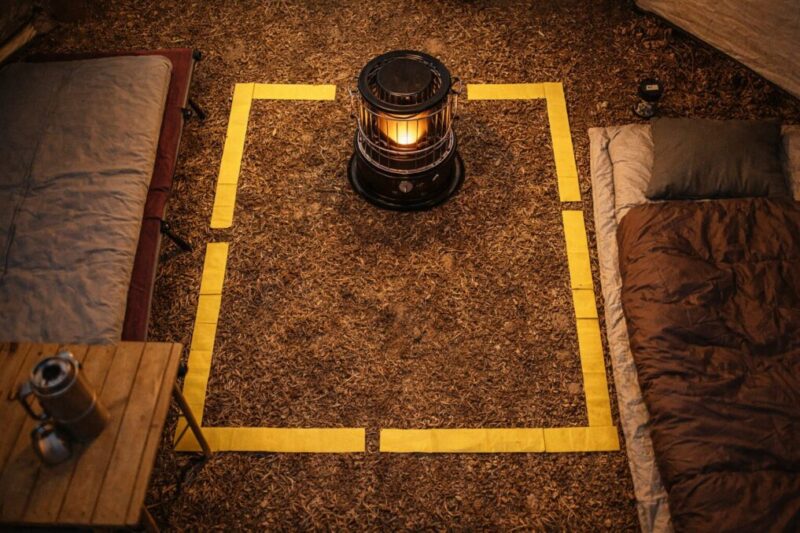転倒や接触を避けるため、ストーブの周囲を空けて寝床と距離を取ったテント内レイアウト例