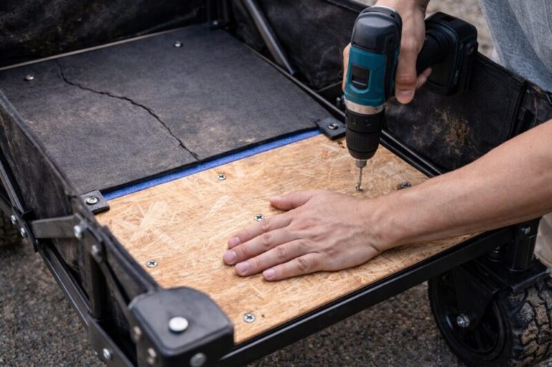 キャリーカートの底板を補強している作業風景