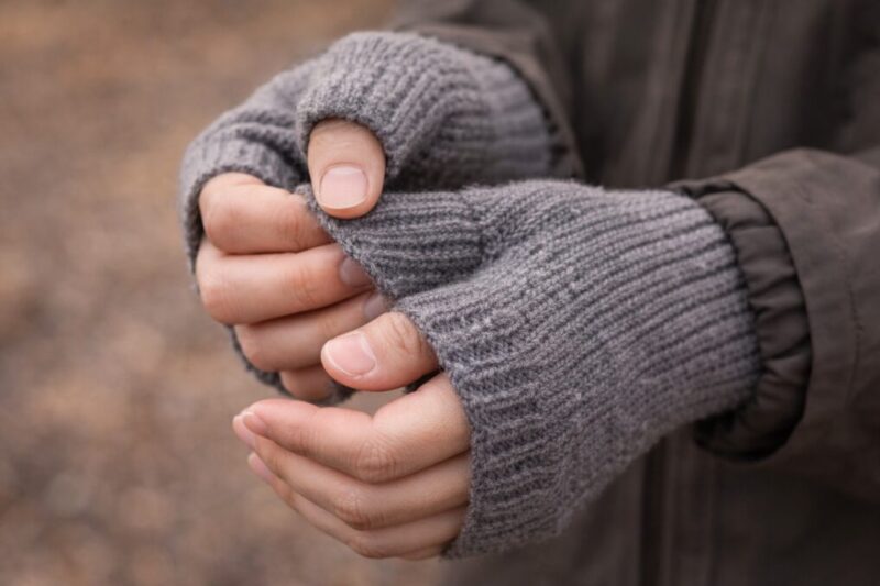 指先が出る手袋を着けた手元をアップで写し、親指穴やフィット感が分かるようにした様子。