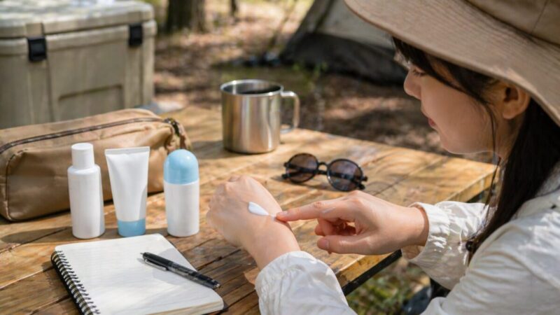 手の甲に日焼け止めを伸ばして使用感を確認しているアウトドアでのレビュー風イメージ