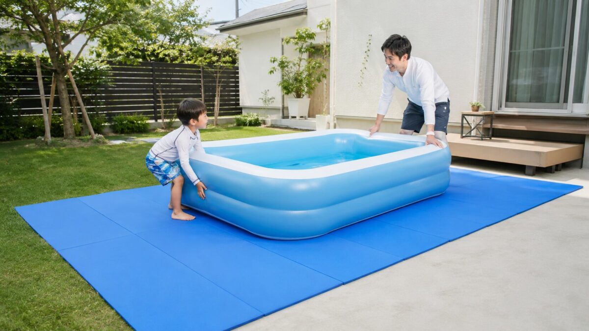 家庭用プールの下に大判の折りたたみマットを敷き、庭で設置する親子