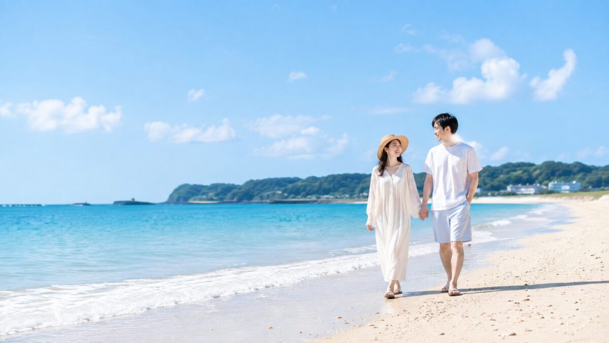 海水浴デートで青い海の波打ち際を手をつないで歩くカップル