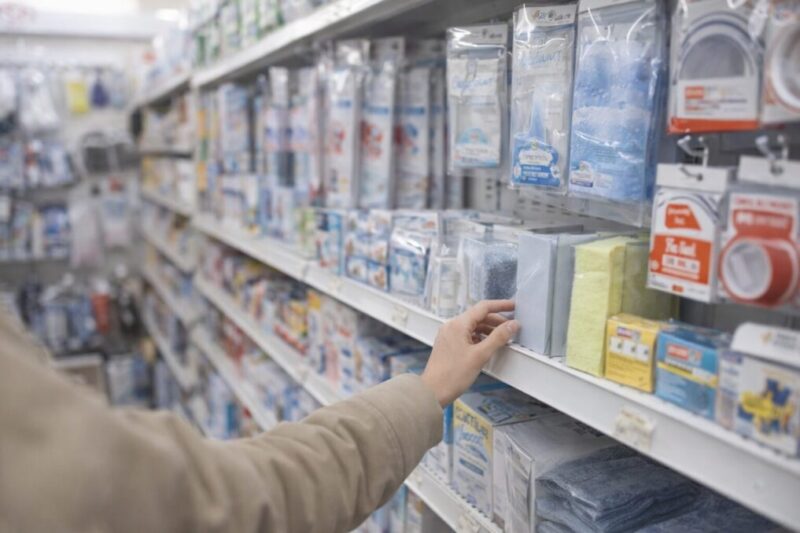 店内の棚を見比べながら、結露対策に使えるシートやテープ類を探している様子のイメージ