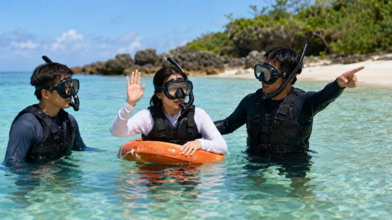 シュノーケリング中の不安を伝え、浮力体につかまりながらガイドと岸へ戻る初心者。