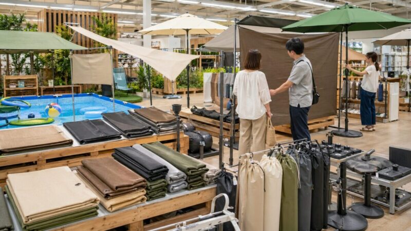 ホームセンターでプール用サンシェードや庭用日除け用品を比較する様子