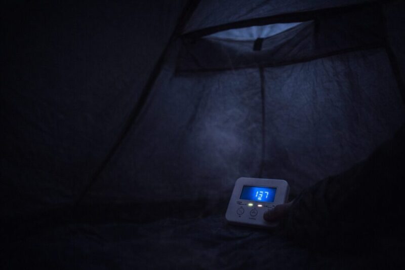 夜のテント内で換気不足が起きやすい状況を示し、警報器と換気の徹底が必要だと伝える様子