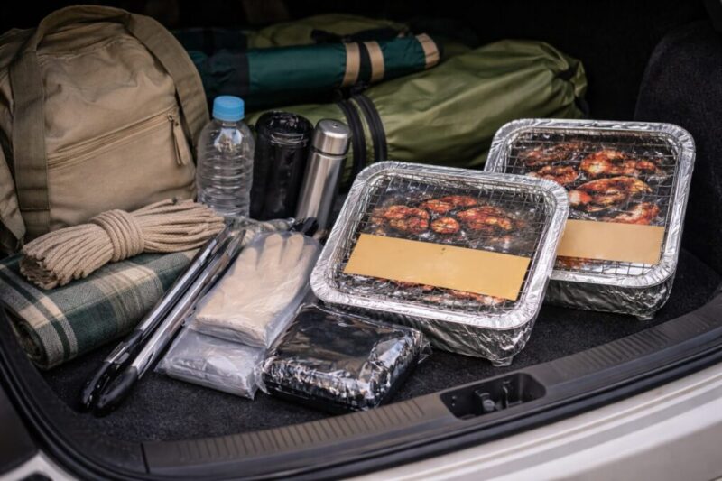 車の荷室に外遊び道具と使い捨てBBQアイテムをまとめ、サイズ感や準備のしやすさを比べている様子