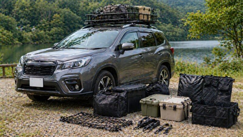 ルーフラックを装着した車のそばに収納ボックスや防水バッグ、カーゴネットを並べた様子