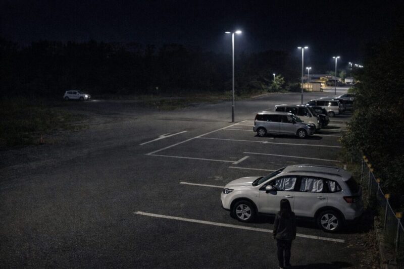 明るく管理された駐車場と暗い空き地の違いが分かる夜の風景