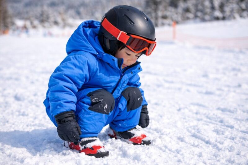 つなぎを着た子どもがしゃがみ込み、動きやすさを確かめている様子