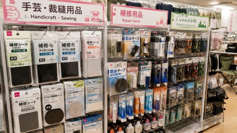 手芸・補修用品・アウトドア小物が並ぶ店内で、補修シートや防水テープを探している売り場の様子