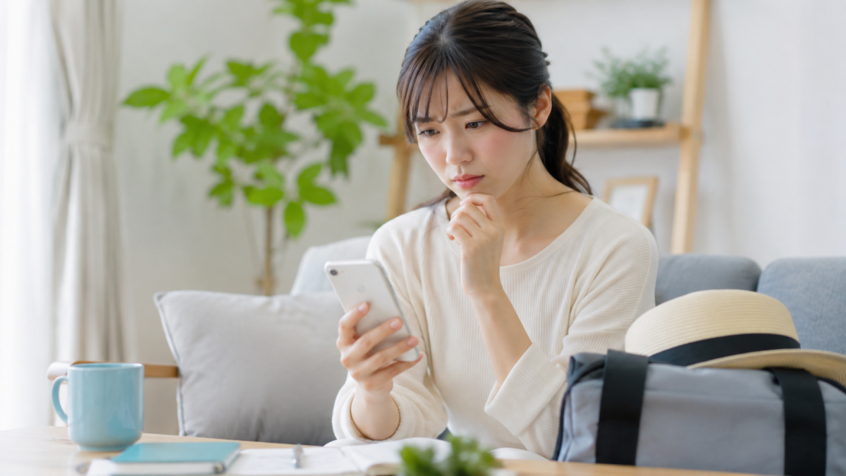 レジャーへ出発する前にスマートフォンで予約内容を確認する女性