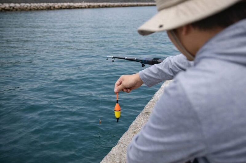 穏やかな堤防で100均のウキ仕掛けを使う初心者の手元イメージ