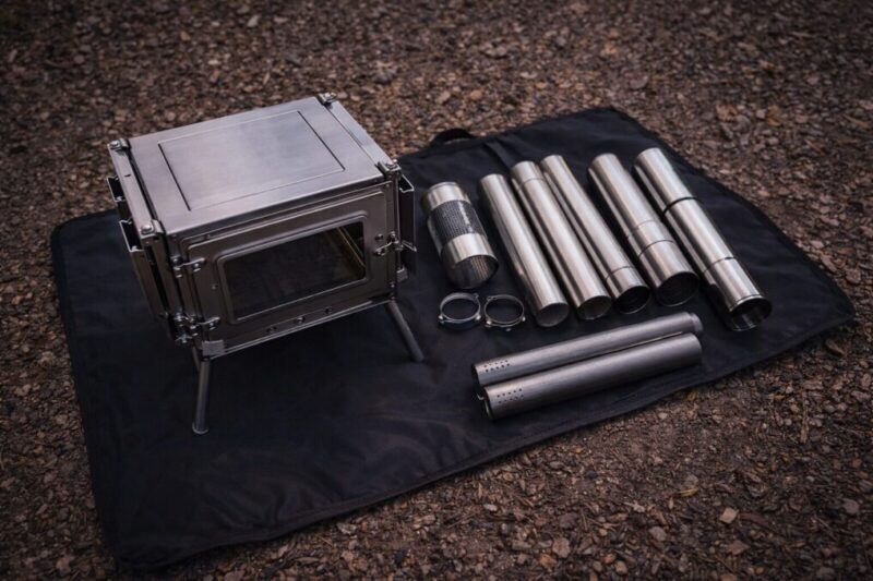 折りたたみ式の小型薪ストーブ本体と分割煙突を並べ、収納サイズを確認できる俯