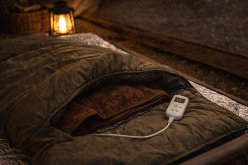 寝袋の足元に電気毛布を部分的に入れて、温度調整しやすい位置にコントローラーを置いた就寝セット