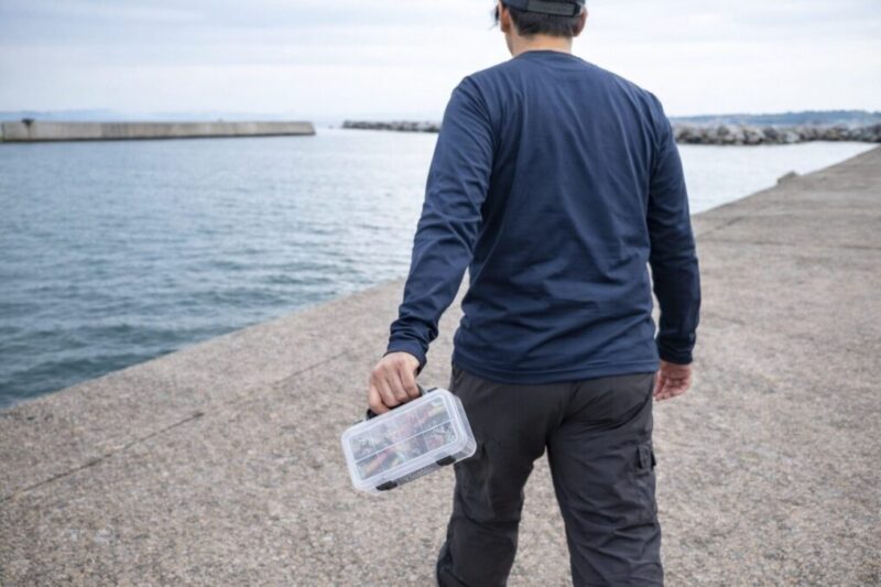 小型の釣り収納を持って防波堤を移動するランガンのイメージ