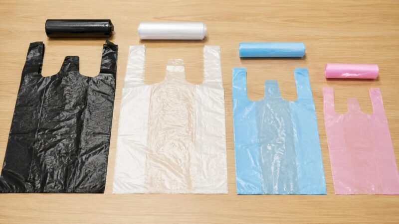 黒、半透明、水色、ピンクのポリ袋を大きさ別に木目テーブルへ並べた比較写真。