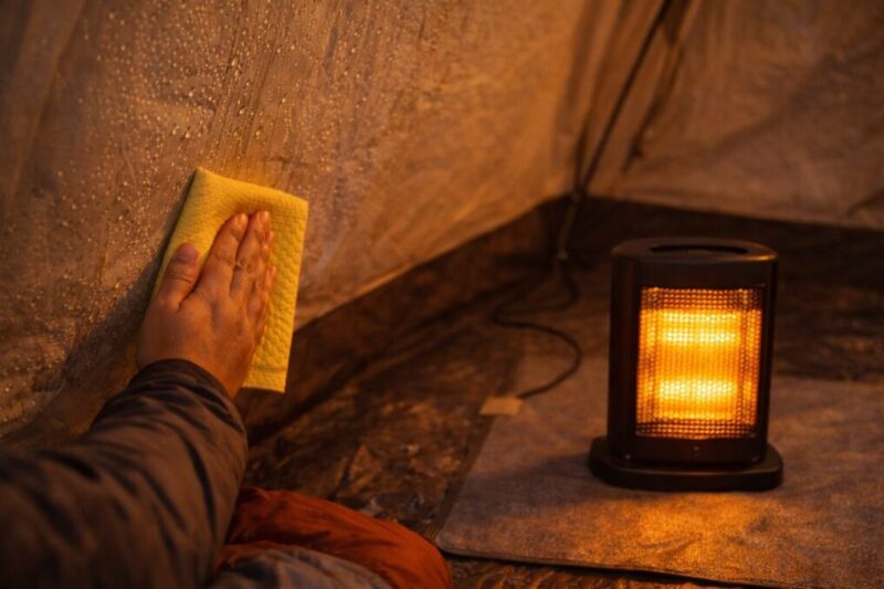 結露したテント内を拭き取りながら、足元を暖めている様子
