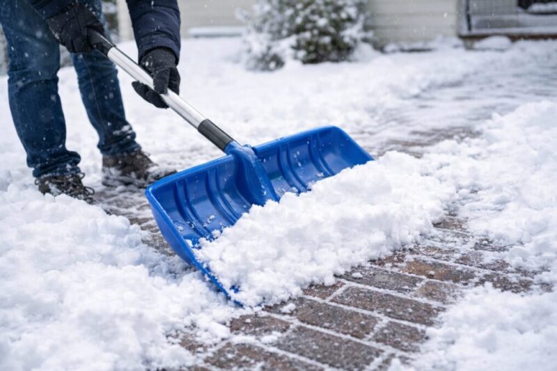 ワイド雪スコップで玄関前の通路の雪を押して時短する様子