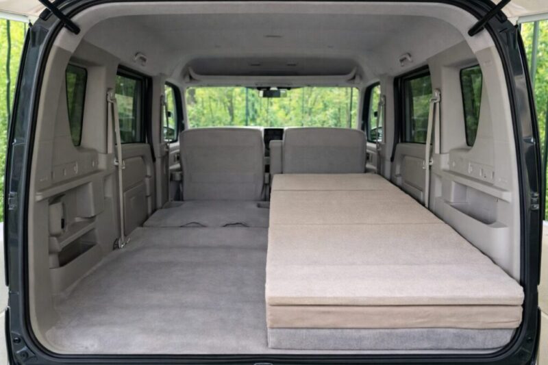 軽バンの車内で片側は床面をそのまま見せ、もう片側だけマットを敷いて寝床を整えた比較イメージ