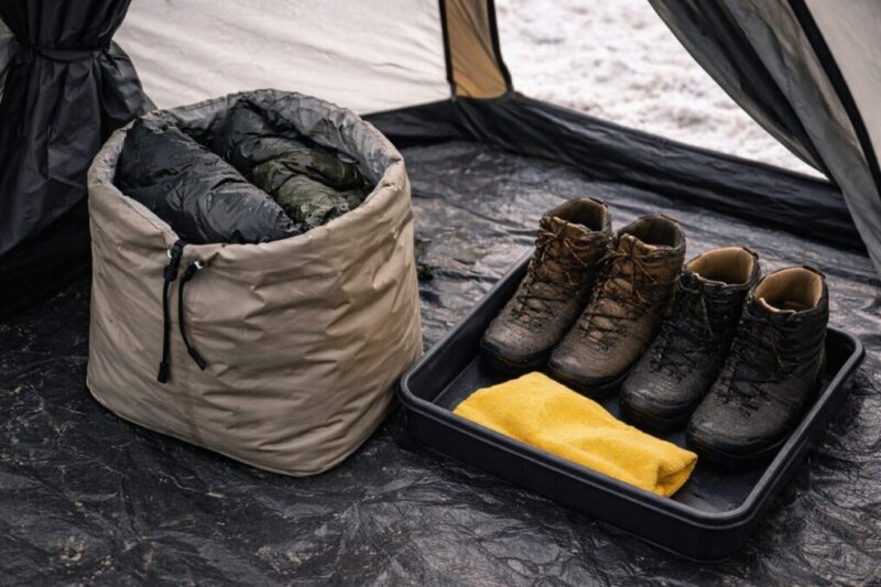 濡れた服や靴を入口付近でまとめて隔離し、テント内の湿気を増やしにくくする工夫のイメージ