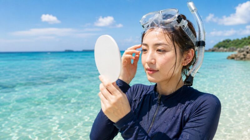 シュノーケリング後に鏡で眉と目元のメイク崩れを確認する女性