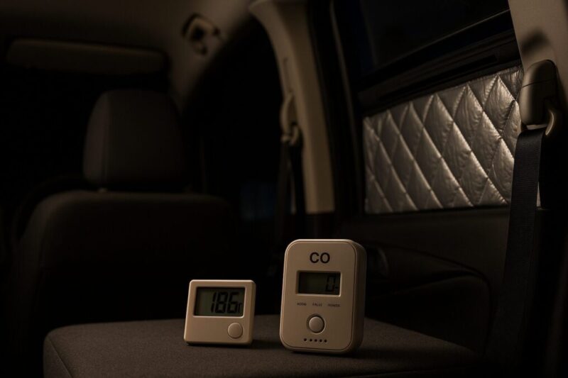 「小窓を少し開けて換気しつつ一酸化炭素チェッカーと温度計を設置した車中泊車内のイメージ」