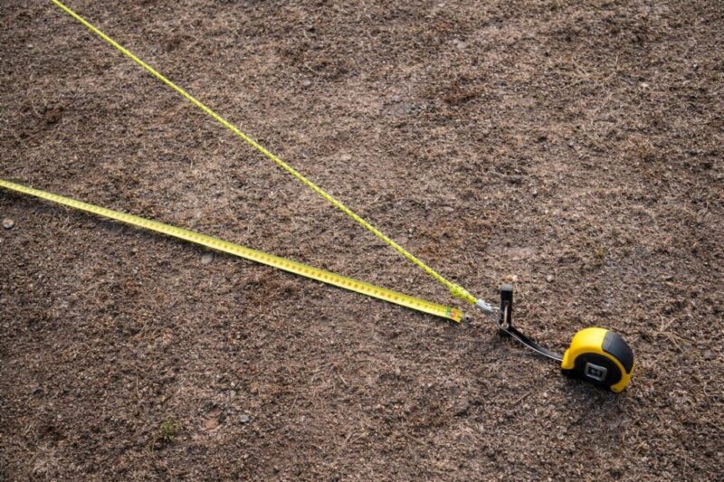 ガイロープの長さとペグ位置の目安を測っているイメージ