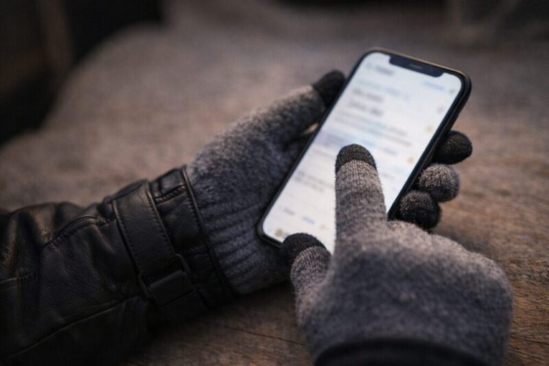 スマホ操作をする手元を写しタッチ対応手袋の使い勝手を連想させる写真