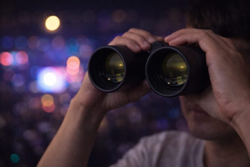 ドーム会場で8倍か10倍かを選びながら双眼鏡を構えるイメージ