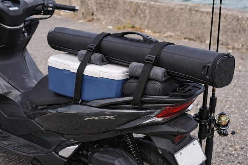 ロッドケースとクーラーボックスを2本のベルトと緩衝材で固定したスクーター後部の積載イメージ