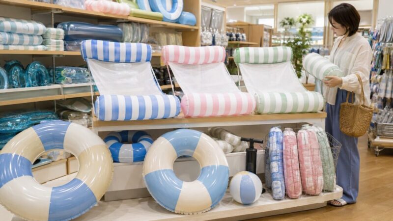 夏の水遊びグッズ売り場でフロートハンモックや浮き輪を確認している様子